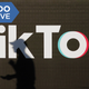 A man's shadow passing in front of the TikTok app.